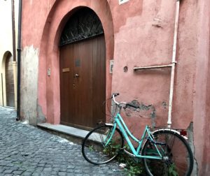 door in Italy with turquoise bike by it.